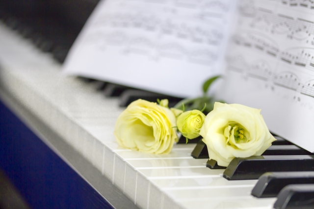 ピアノの鍵盤と花と楽譜